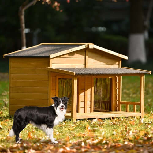 Large wooden dog house with porch in outdoor setting, featuring a black and white dog in front.
